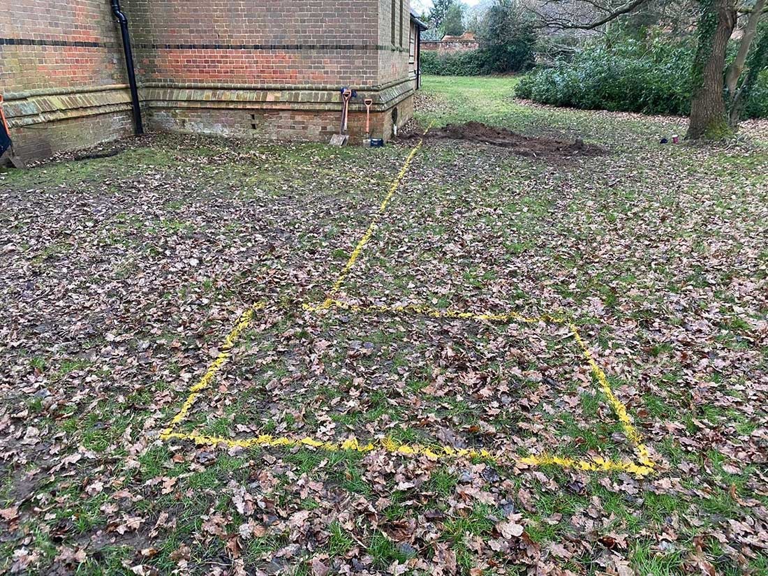 Yellow paint marking a mapped drain route across a Berkshire garden after a CCTV drain survey